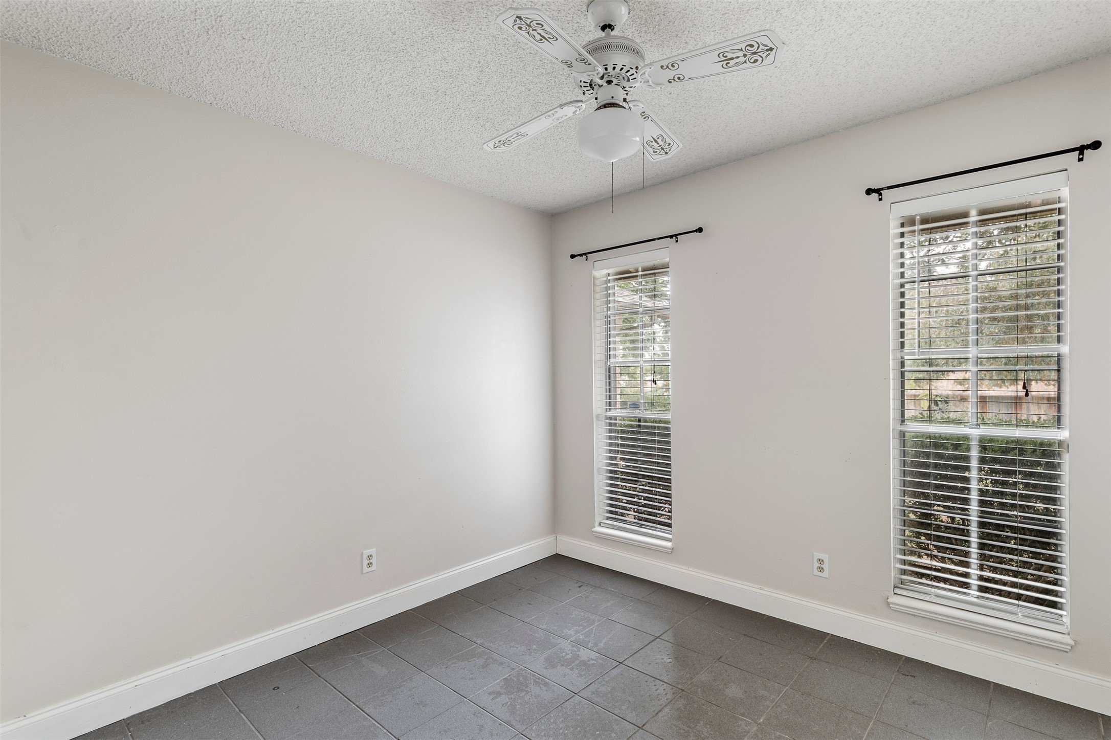 7506 Glenhill Road Austin, TX 78752 - Photo 13 of 24 Well-lit room with durable tile flooring and two large windows offering ample natural light.