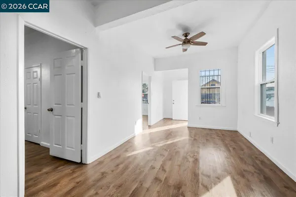 a view of a livingroom with wooden floor and a ceiling fan