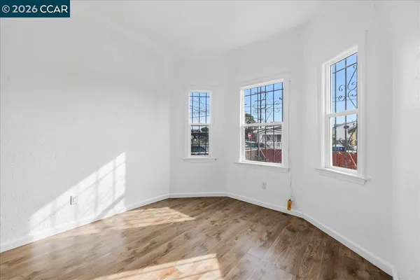 a view of empty room with wooden floor