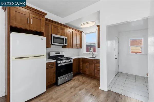 a kitchen with granite countertop a refrigerator stove and microwave