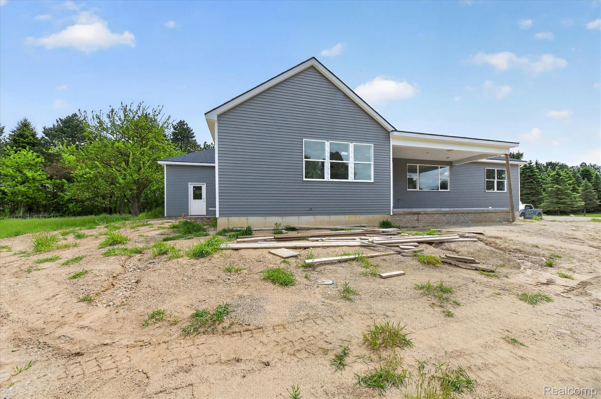 3297 Oak Grove Road Howell, MI 48855 - Photo 24 of 40 Covered rear patio overlooking the spacious backyard and natural surroundings.
