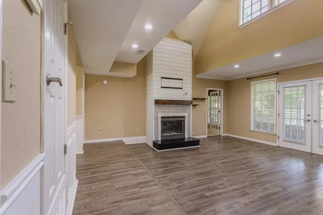 a view of a livingroom with wooden floor and a fireplace