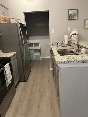 a kitchen with sink refrigerator and microwave