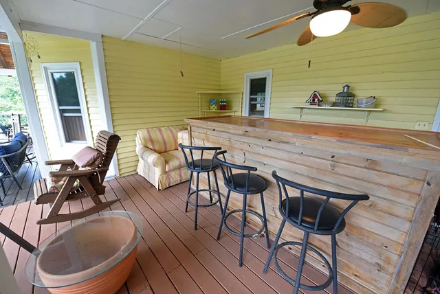 a view of a chairs and table in patio with wooden floor