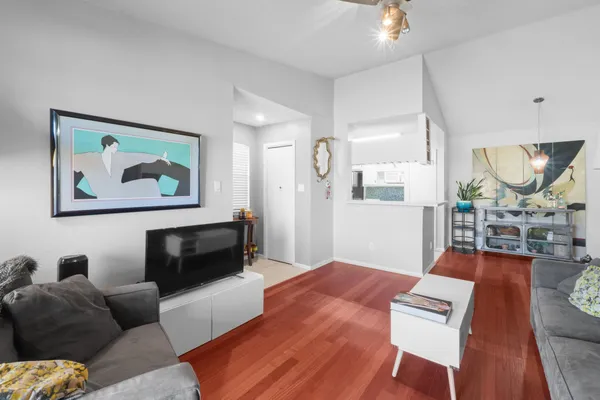 a living room with furniture a table and wooden floor