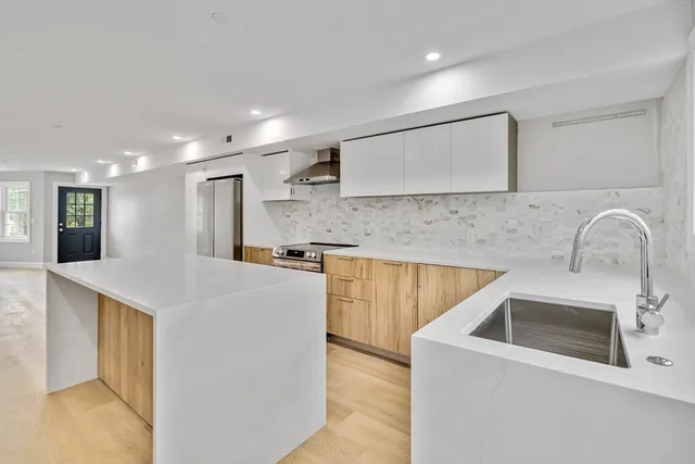 a kitchen with stainless steel appliances granite countertop a sink a stove and a refrigerator