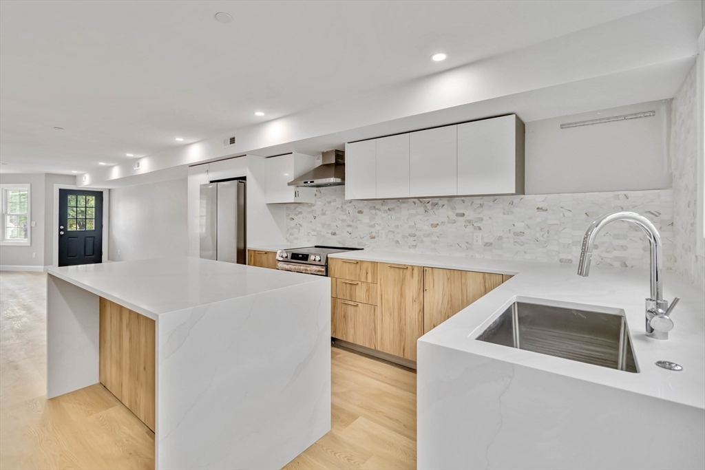 192 Main Street, Unit D Medway, MA 02053 - Photo 13 of 39 a kitchen with stainless steel appliances granite countertop a sink a stove and a refrigerator