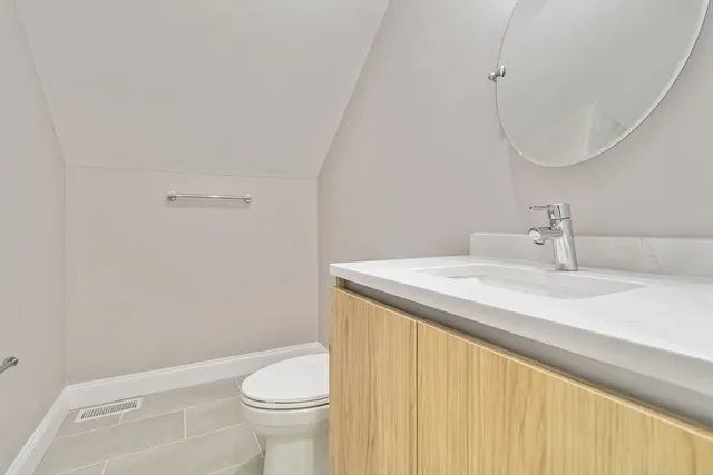 a bathroom with a sink a toilet and a mirror