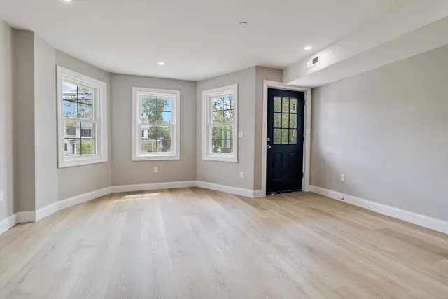 an empty room with windows and closet