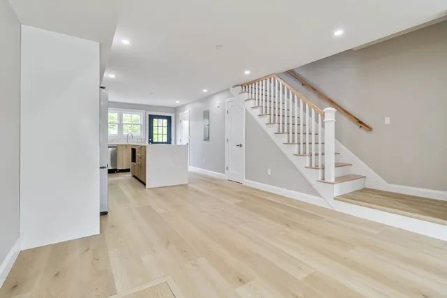 a view of a hallway with wooden floor and staircase