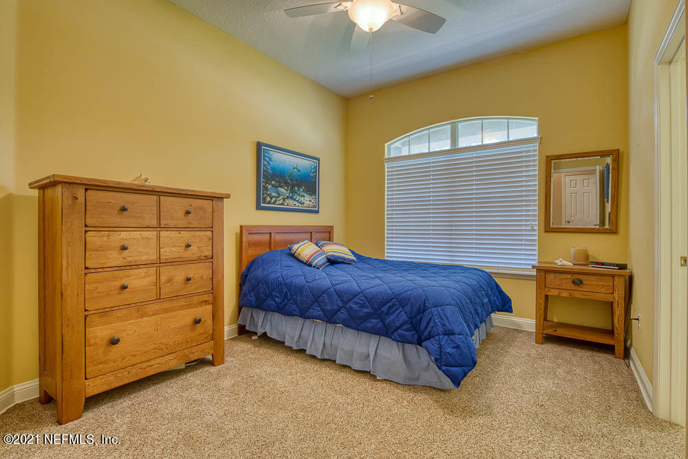 11590 Mandarin Road Jacksonville, FL 32223 - Photo 25 of 46 a spacious bedroom with a bed and a chandelier