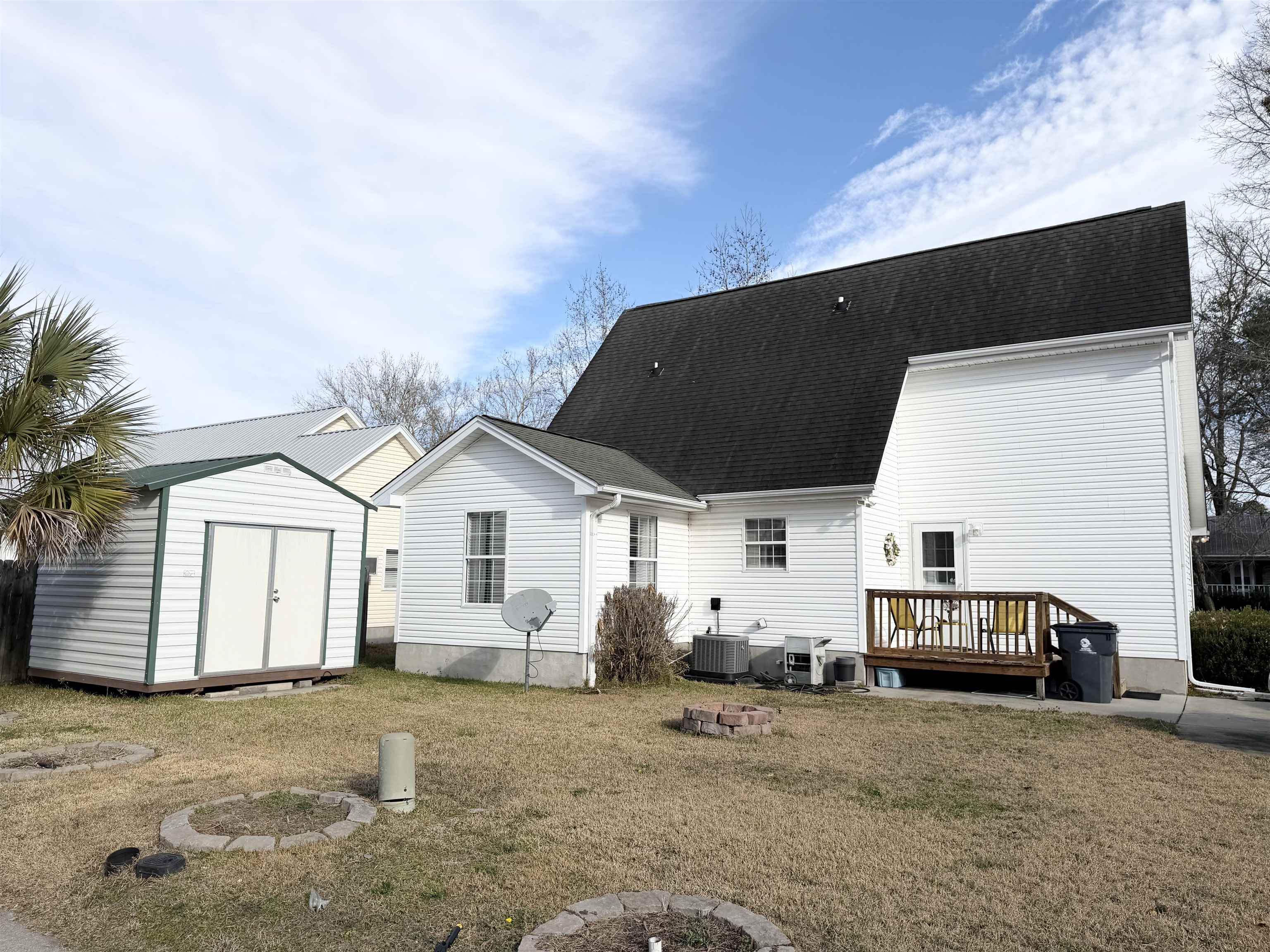 106 Sly Fox Trail Myrtle Beach, SC 29588 - Photo 13 of 14 Rear view of house with a fire pit, a deck, a shed, roof with shingles, and a yard