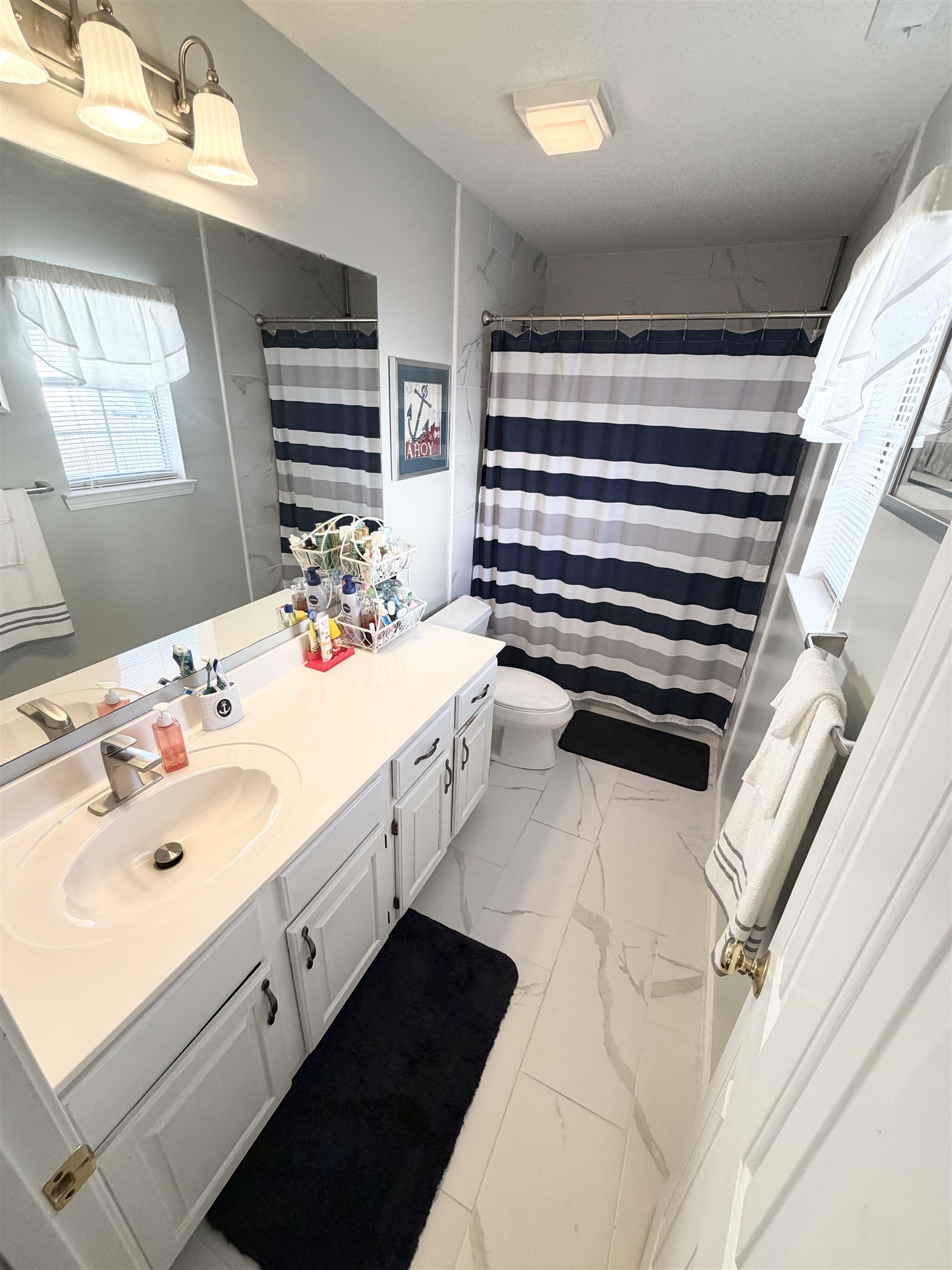 106 Sly Fox Trail Myrtle Beach, SC 29588 - Photo 9 of 14 Bathroom featuring vanity, light marble finish flooring, and a shower with curtain