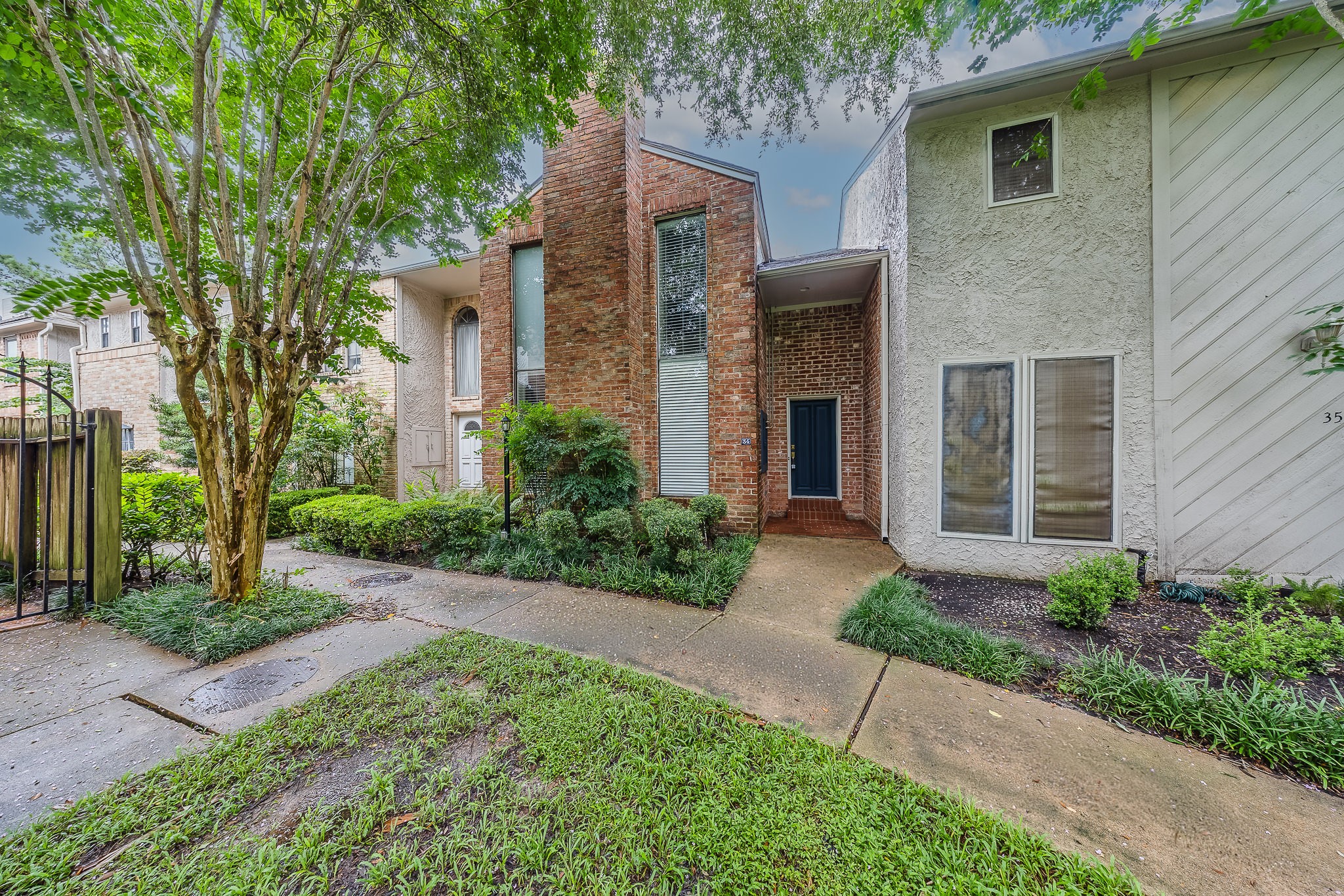 727 Bunker Hill Road, Unit 34 Houston, TX 77024 - Photo 10 of 38 Stunning curb appeal featuring a classic brick facade and beautifully maintained landscaping.