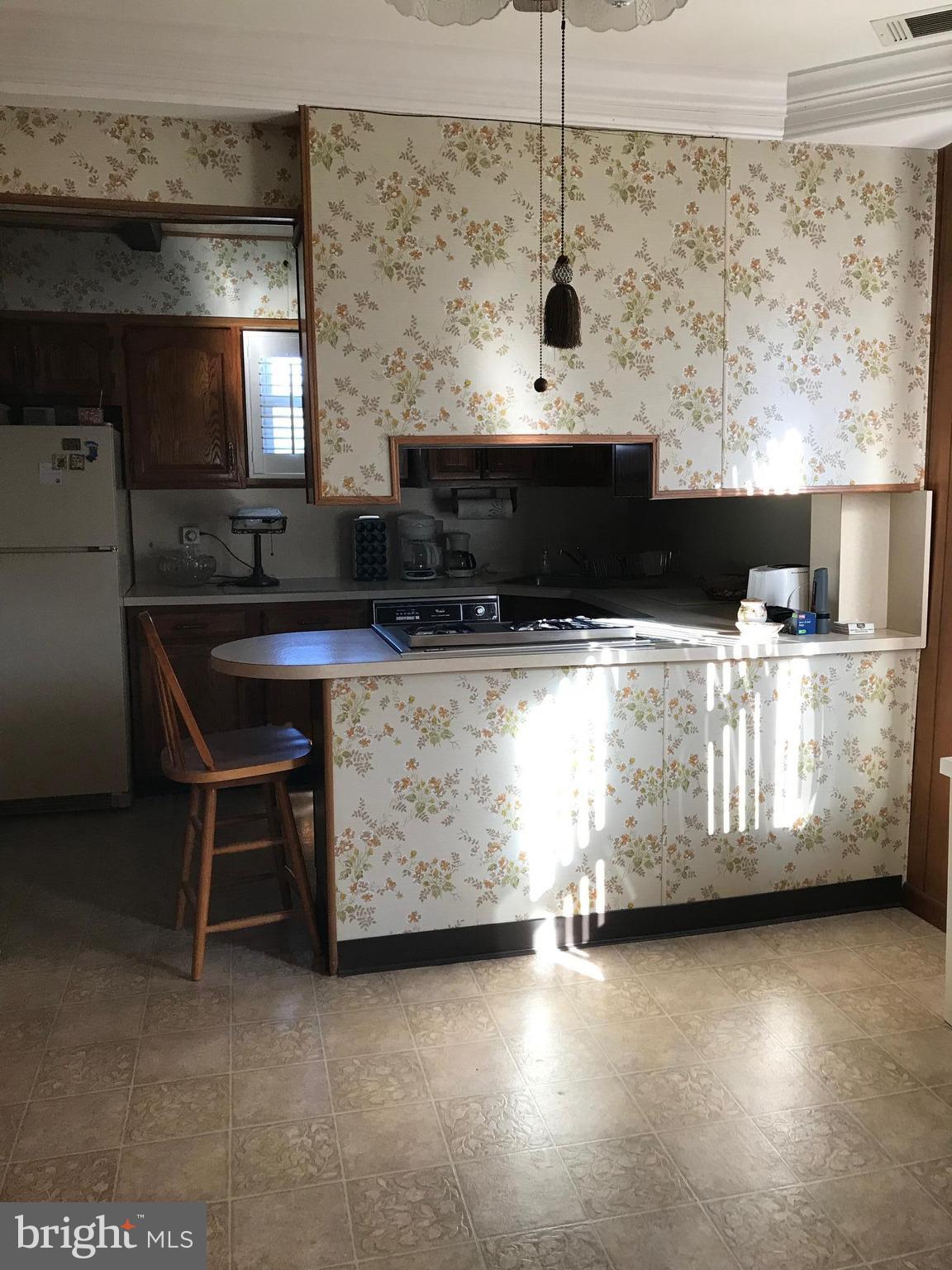 1831 Portship Road Baltimore, MD 21222 - Photo 6 of 17 a kitchen with a table and a fireplace