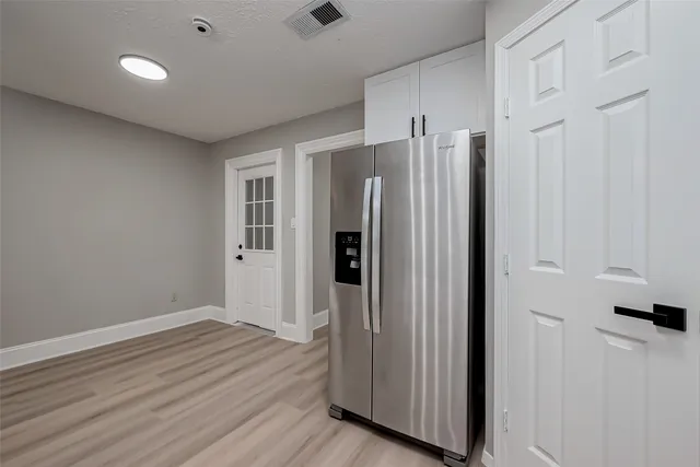 an empty room with wooden floor ceiling fan and windows