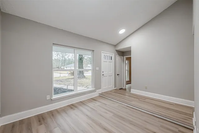 wooden floor in an empty room with a window