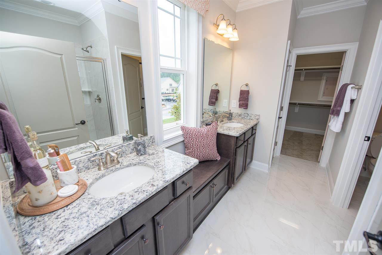 709 Wildflower Ridge Road, Unit 375 Wake Forest, NC 27587 - Photo 13 of 25 Tiled shower with a bench, separate vanities, and a huge walk-in closet with built-in shelving.