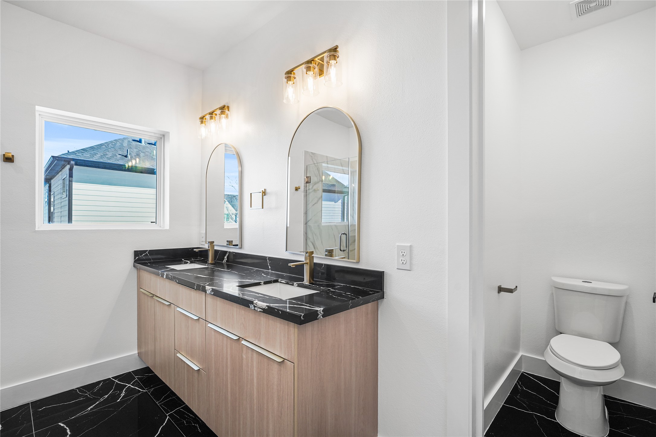 3405 Baer Street Houston, TX 77020 - Photo 17 of 28 a bathroom with a granite countertop toilet a sink and a mirror