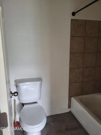a white toilet sitting next to a bathtub
