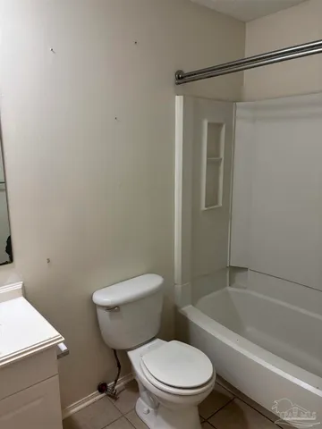 a white toilet and tub sitting next to a bathroom sink