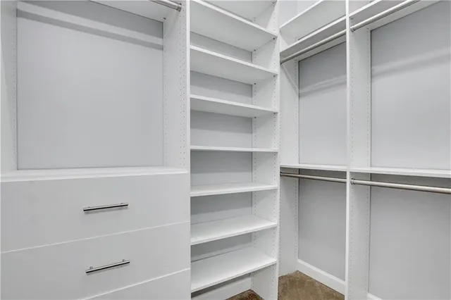 a view of walk in closet with empty racks
