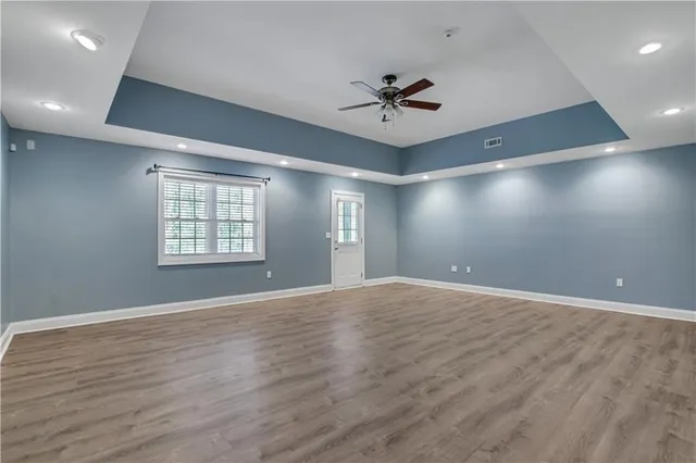a view of an empty room with window and wooden floor