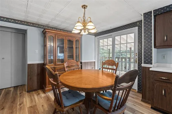 a dining room with furniture a chandelier and wooden floor