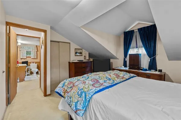 a bedroom with a bed and a painting on the wall