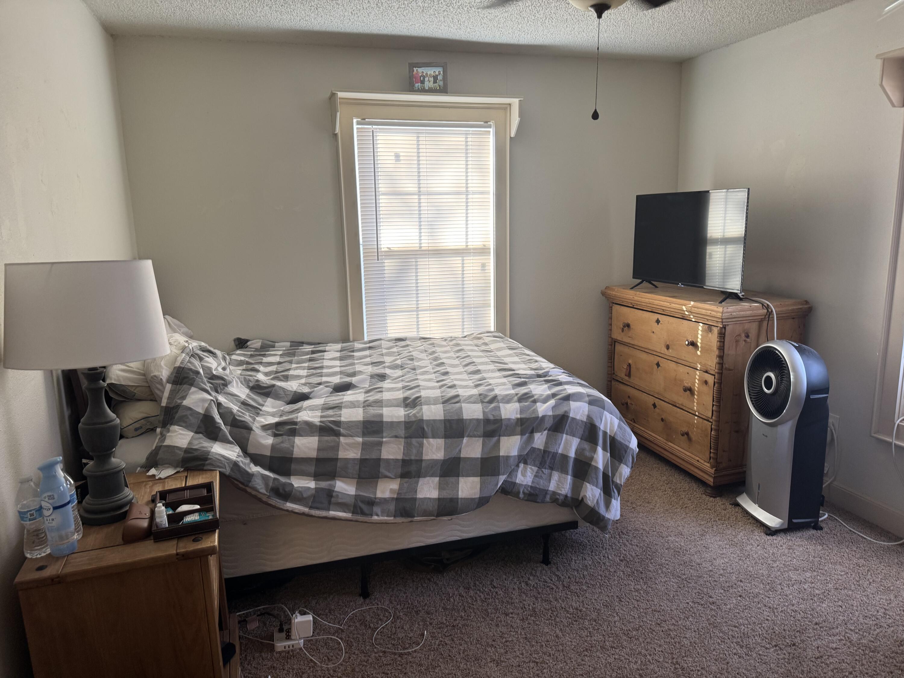 2610 27th Street Lubbock, TX 79410 - Photo 4 of 7 a bedroom with a bed and a tv
