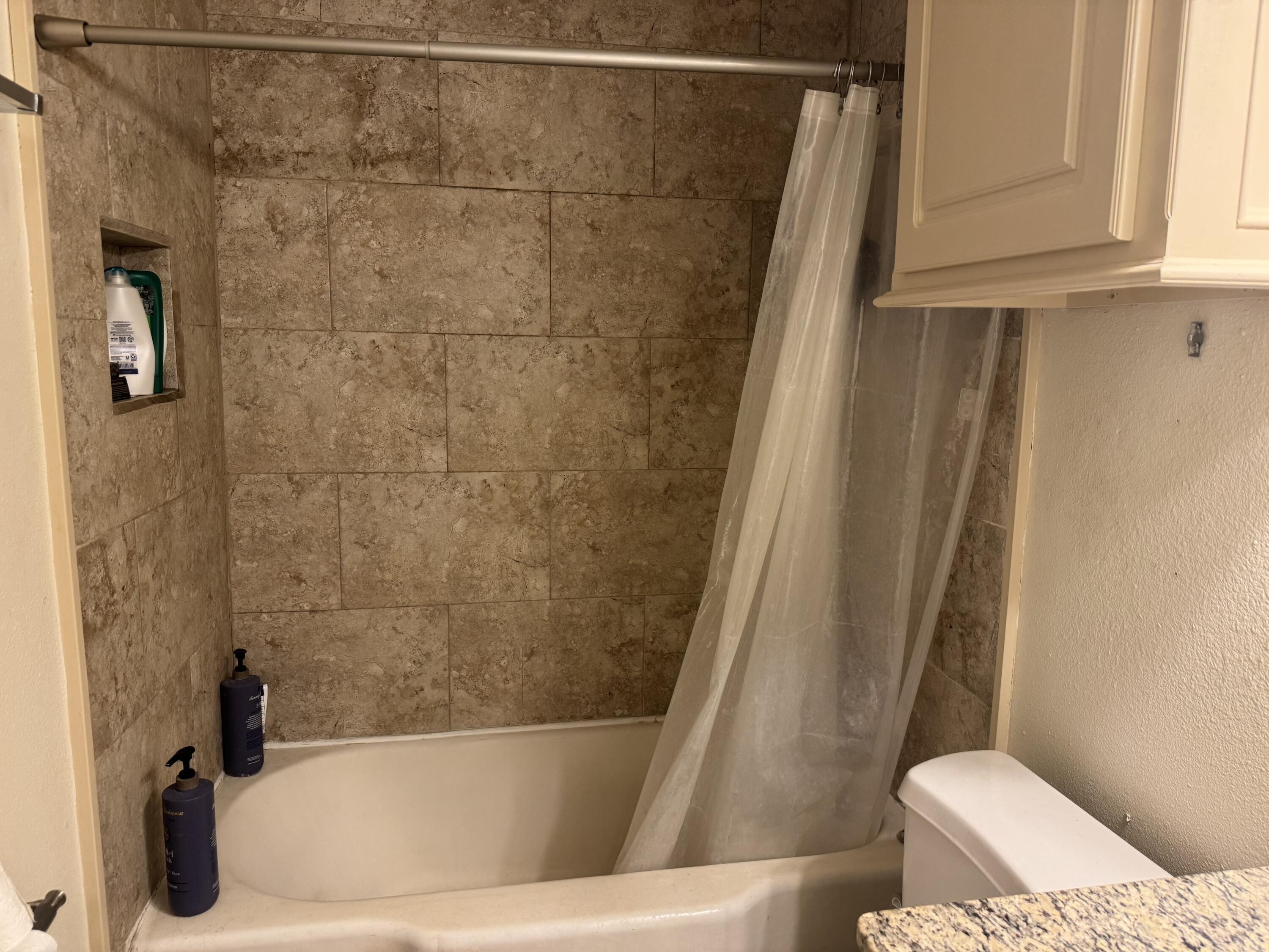 2610 27th Street Lubbock, TX 79410 - Photo 5 of 7 a bathroom with a tub and a toilet