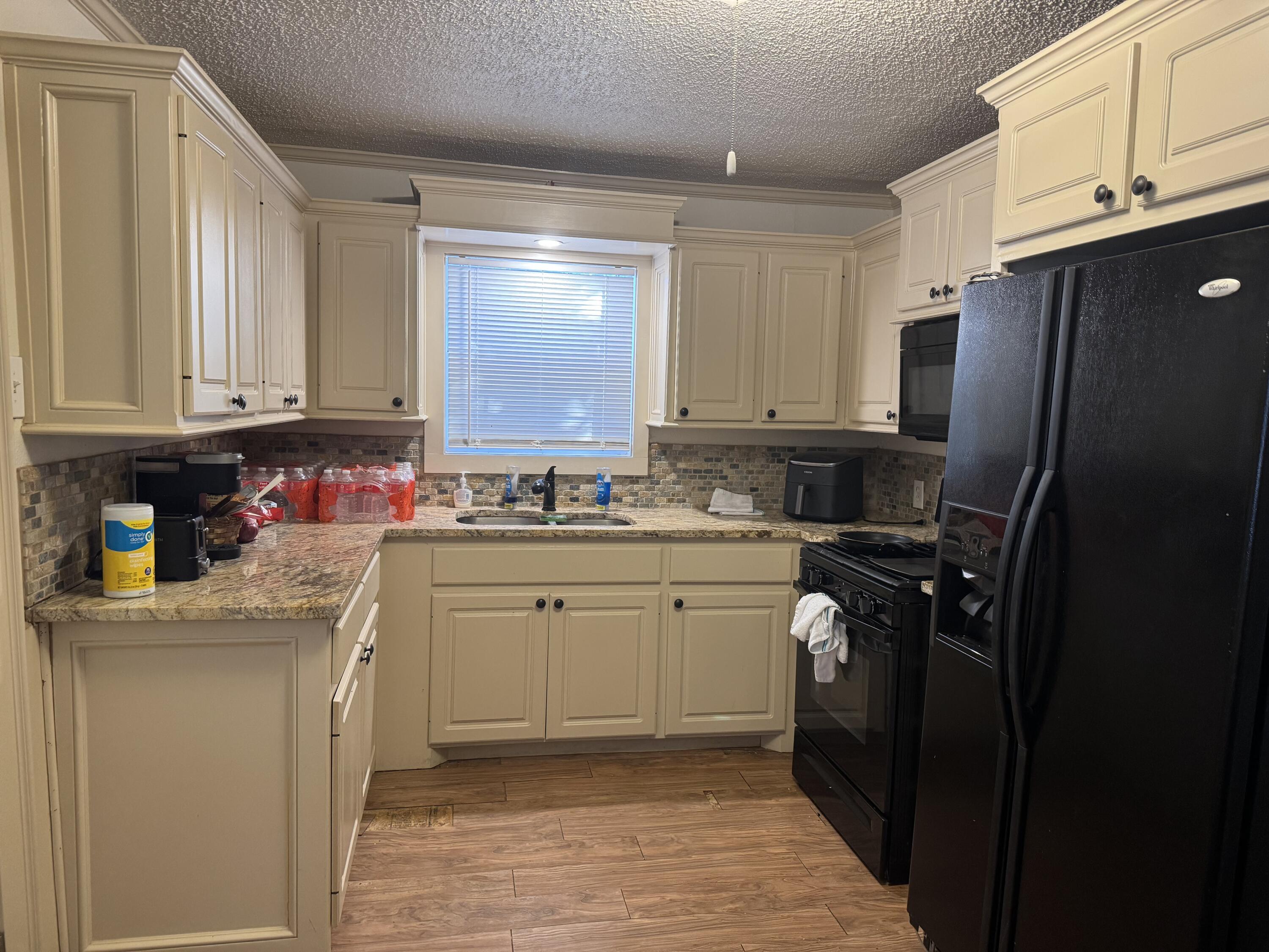 2610 27th Street Lubbock, TX 79410 - Photo 6 of 7 a kitchen with stainless steel appliances granite countertop a refrigerator stove and sink
