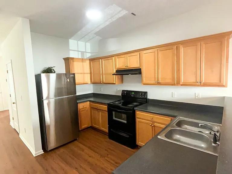 1493 Ashley Way Atlanta, GA 30344 - Photo 3 of 10 a kitchen with stainless steel appliances granite countertop a refrigerator a sink dishwasher a stove and white countertops with wooden floor