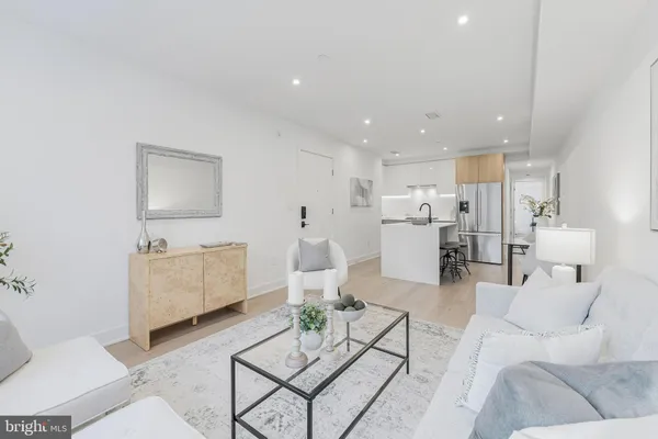 a living room with furniture and view of kitchen