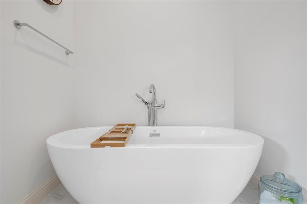 12014 Kenai Circle Woodway, TX 76712 - Photo 22 of 39 a white tub sitting in a bathroom