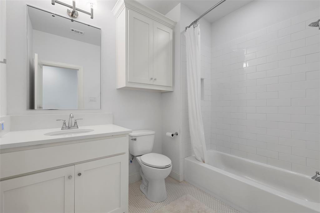 12014 Kenai Circle Woodway, TX 76712 - Photo 32 of 39 a bathroom with a toilet a sink a mirror and a bathtub