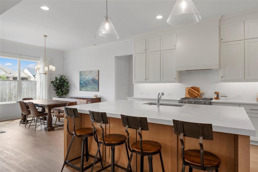 12014 Kenai Circle Woodway, TX 76712 - Photo 9 of 39 a kitchen with a dining table chairs and white cabinets