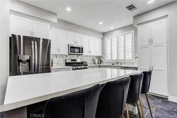 a kitchen with stainless steel appliances a microwave sink refrigerator and cabinets