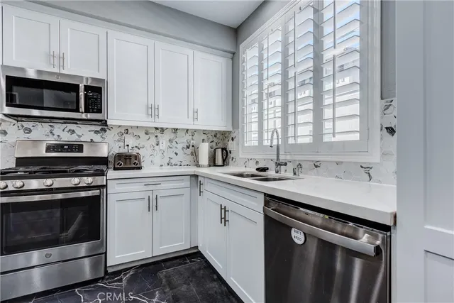 a kitchen with stainless steel appliances granite countertop a sink stove a microwave and cabinets