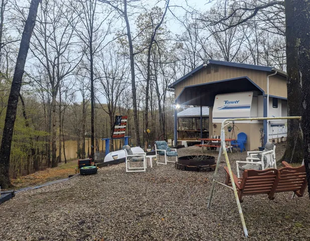 a view of a house with a yard fire pit and furniture