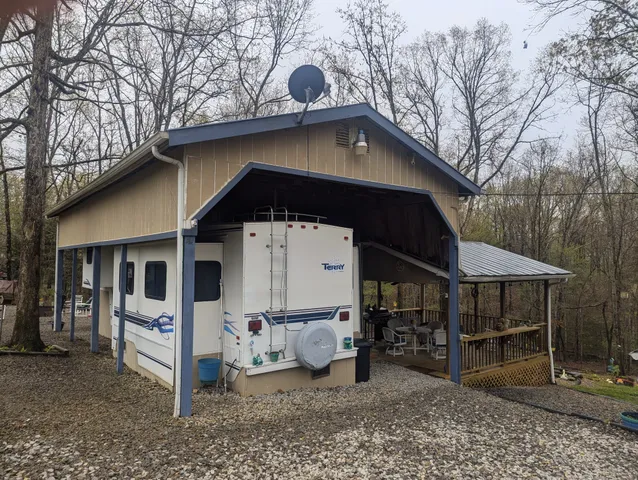 a view of a wooden house with a yard and seating space