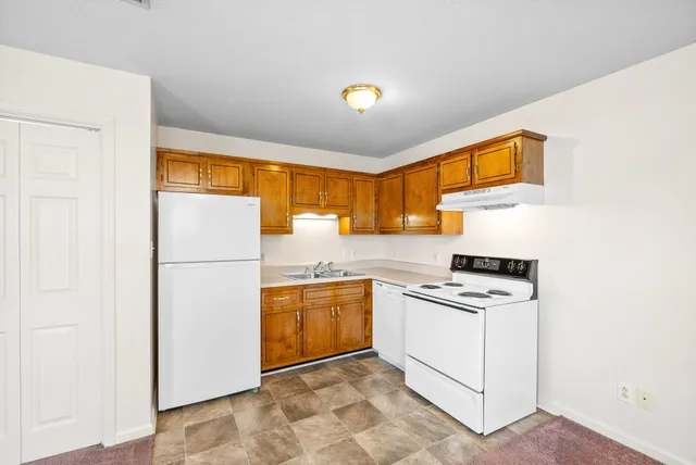 a kitchen with a stove a refrigerator and a sink