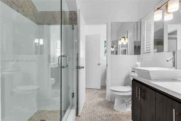 a bathroom with a sink vanity mirror and toilet