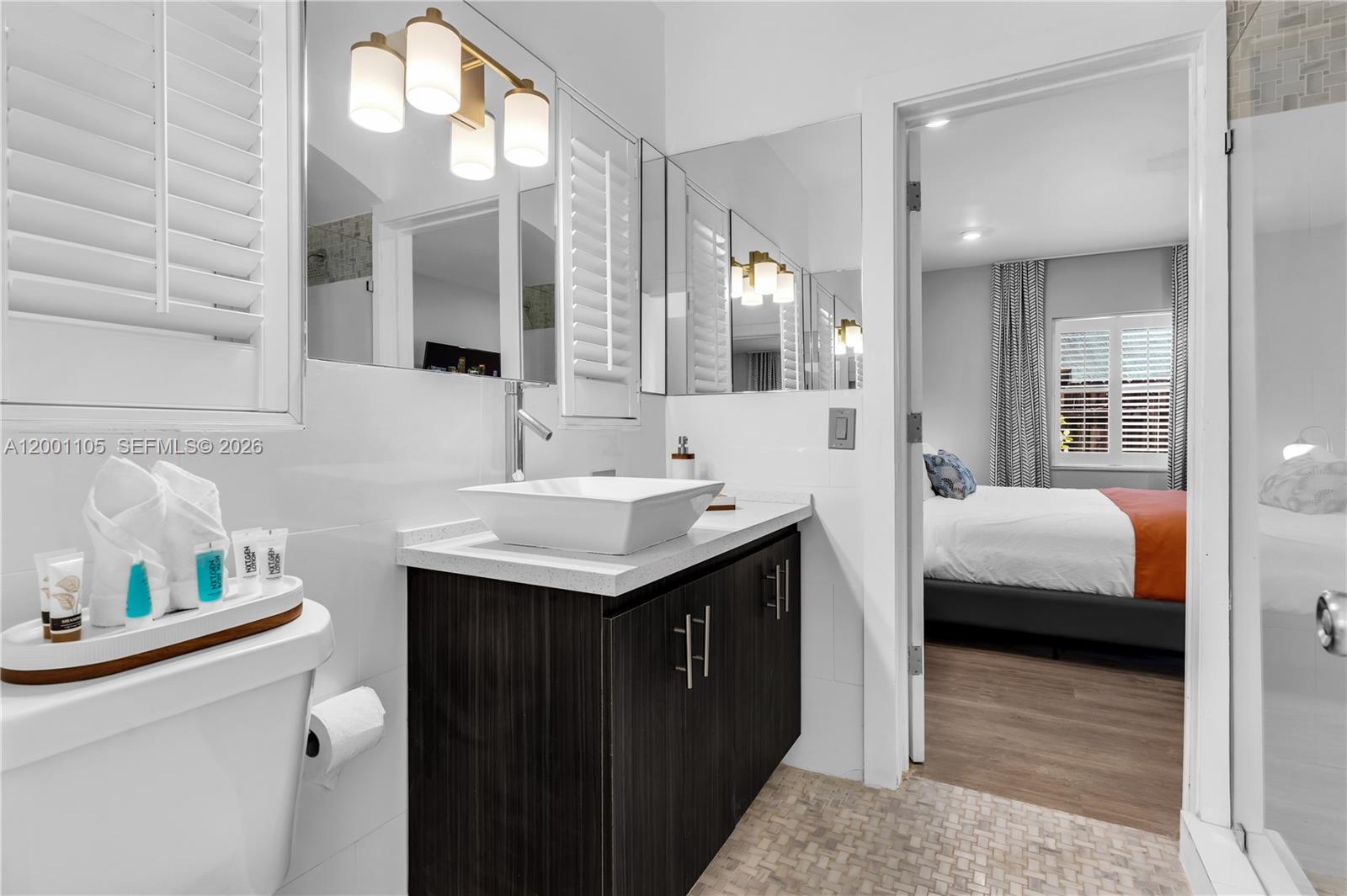 8101 Harding Avenue Miami Beach, FL 33141 - Photo 14 of 34 a en suite bathroom with a double vanity sink and a mirror