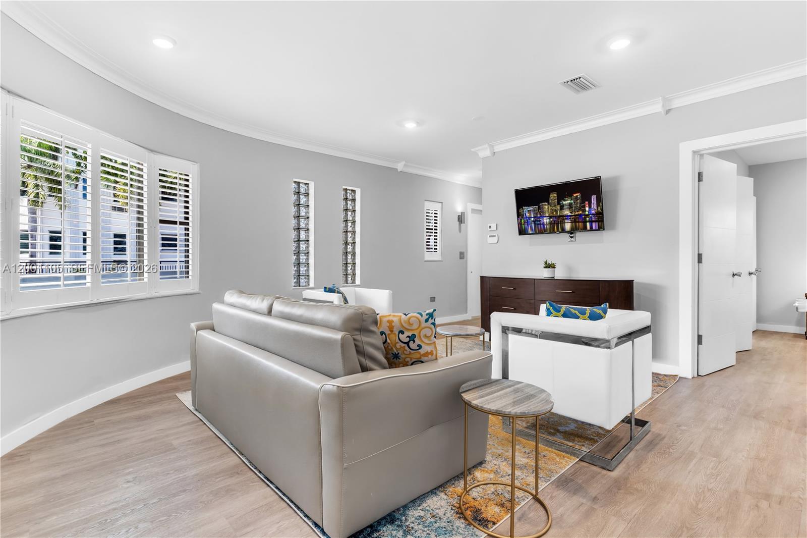 8101 Harding Avenue Miami Beach, FL 33141 - Photo 3 of 34 a living room with furniture and a flat screen tv