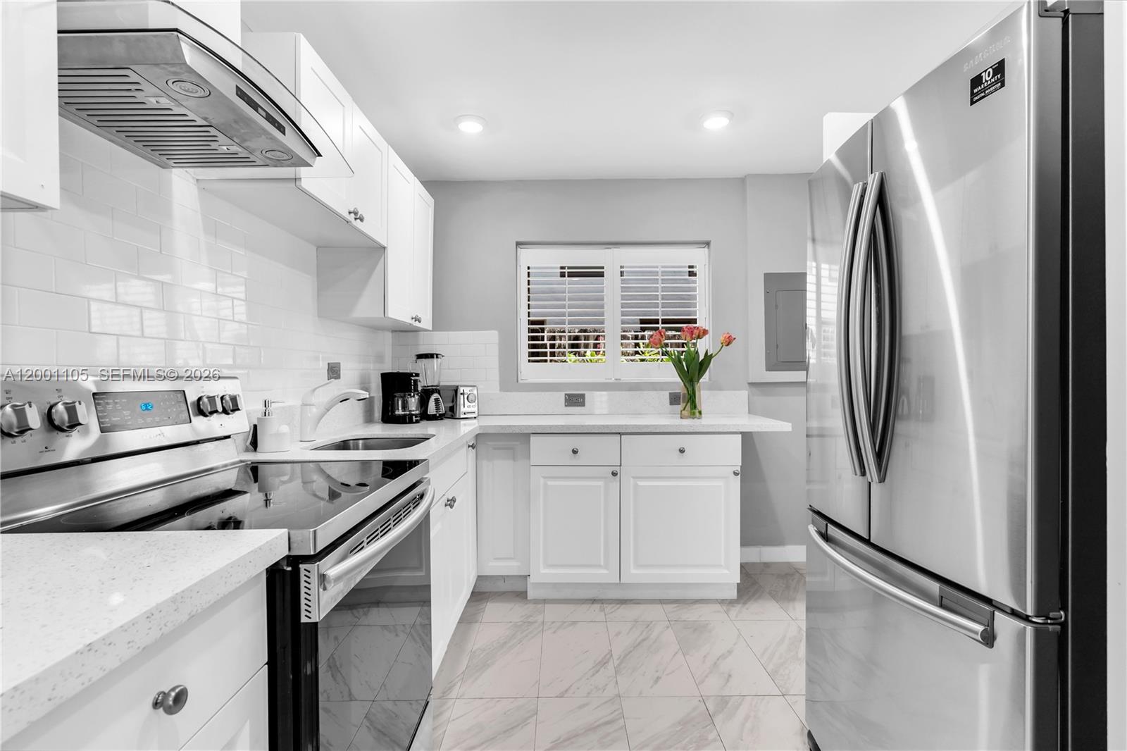 8101 Harding Avenue Miami Beach, FL 33141 - Photo 6 of 34 a kitchen with stainless steel appliances a refrigerator sink and stove