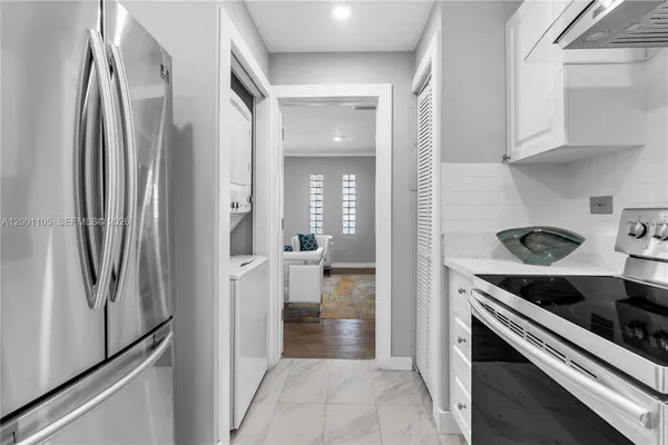 a kitchen with stainless steel appliances granite countertop a refrigerator and a stove