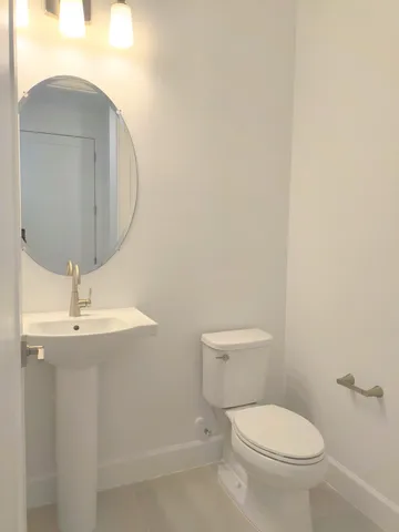 a bathroom with a toilet a sink and mirror
