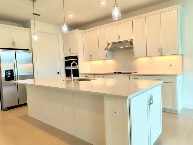 a kitchen with stainless steel appliances granite countertop a sink and a refrigerator