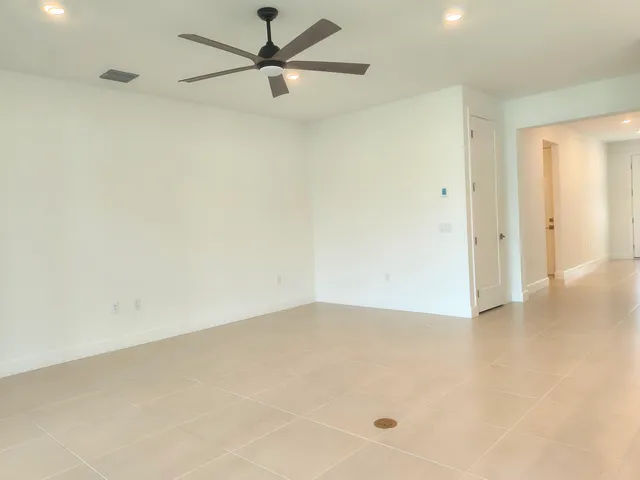 an empty room with a ceiling fan and a window